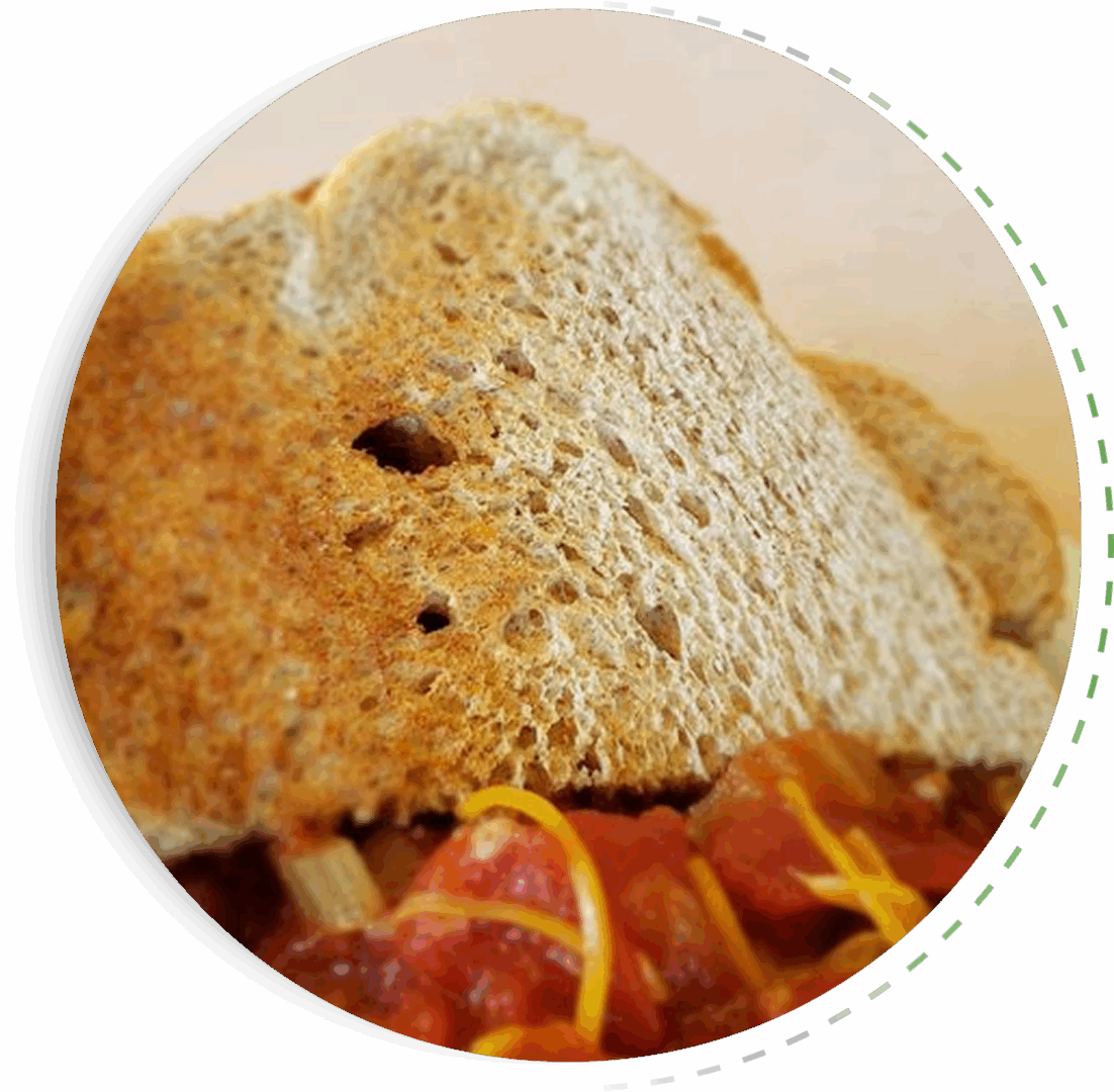 Close-up of a sandwich with turkey, bacon, and melted cheese.